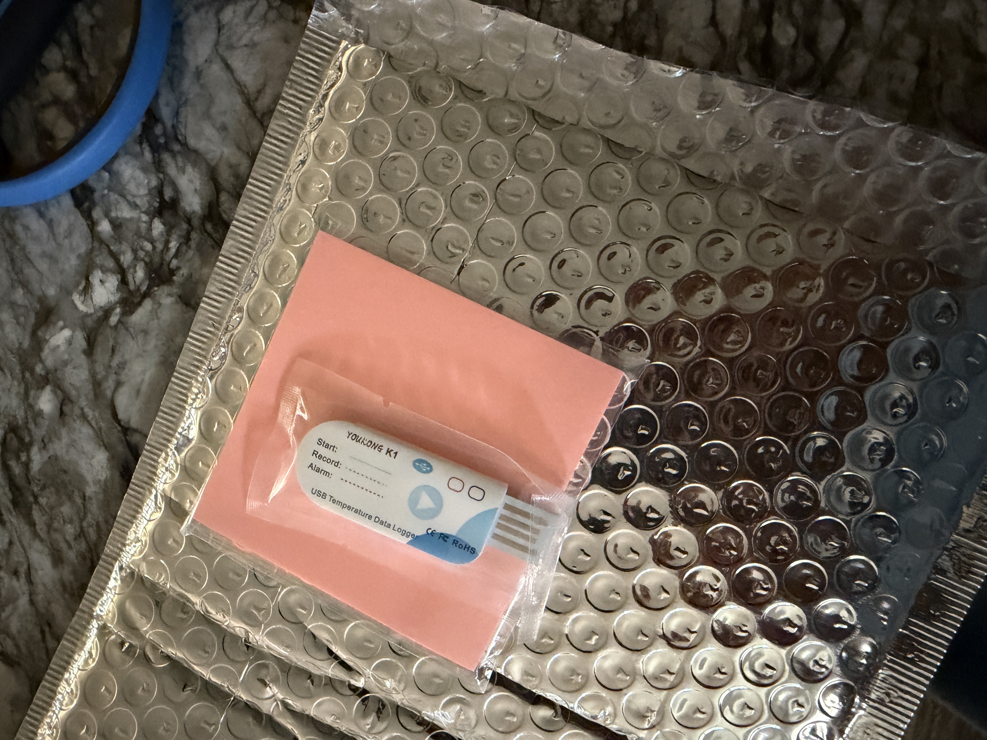 Photograph of a temperature data logger in a demonstration shipment during PharmacyChecker Cold-Chain Certification auditing, June 2026